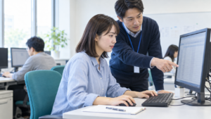 パソコン講座で、講師の説明を受けながら表計算の実習をする若い女性