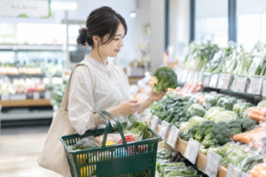 生活費を考えながらスーパーで日常の食材を選ぶ女性