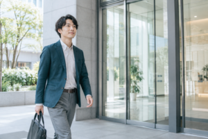 新しい職場への初出勤でオフィスビルに入る男性
