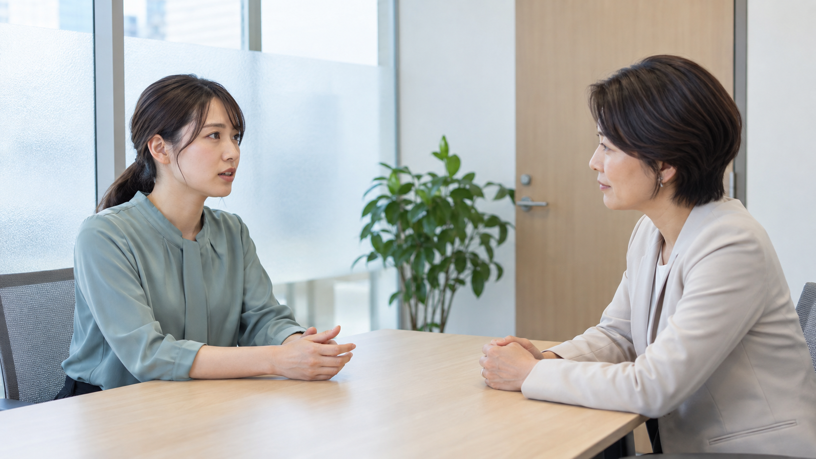 会社の個室で、上司に退職の意向を落ち着いて伝える若い女性
